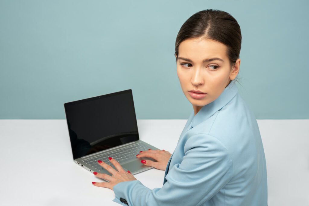 hostile-work-environment office worker looking nervously over her shoulder
